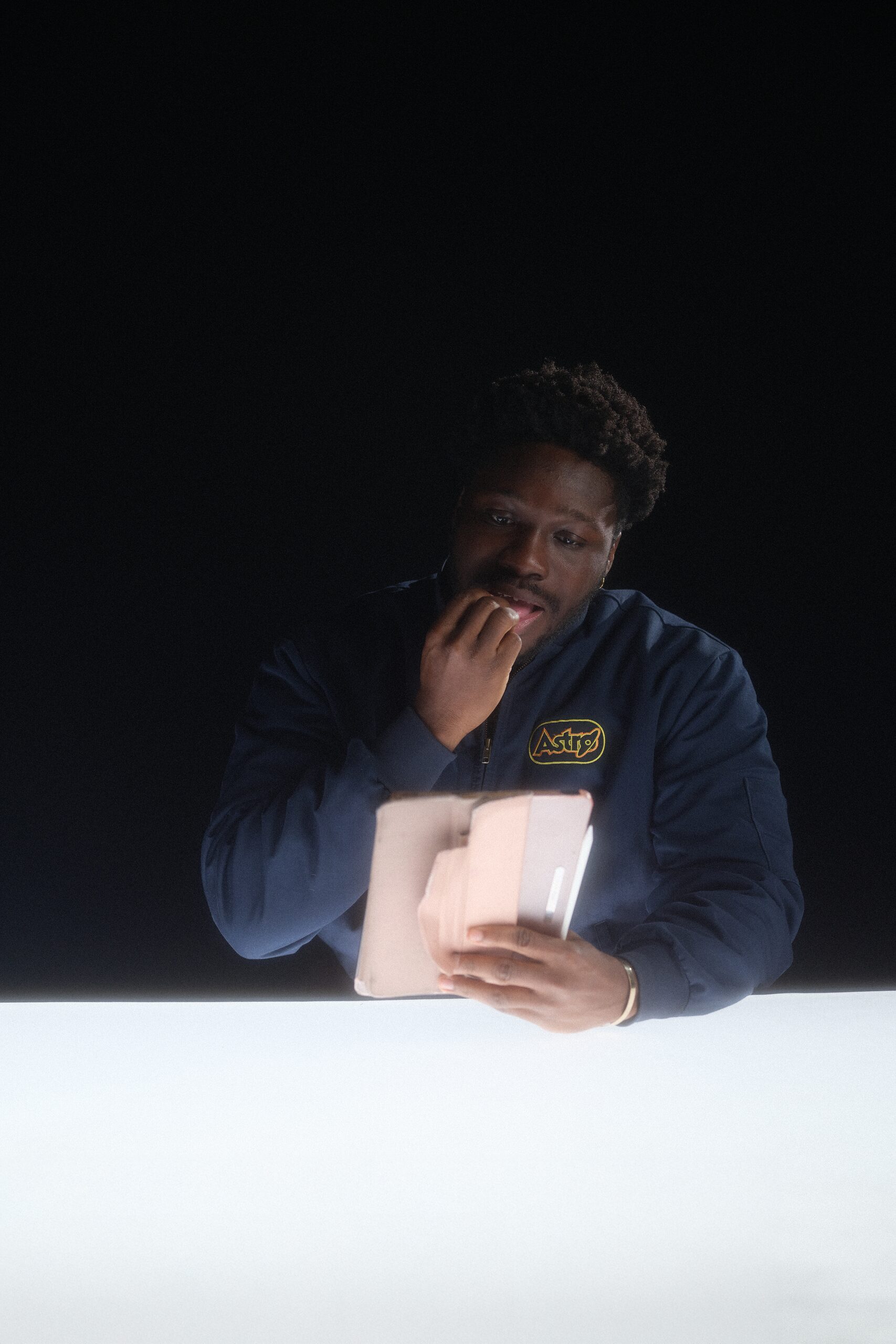 Studio portrait of a subject in an ATC jacket holding a tablet