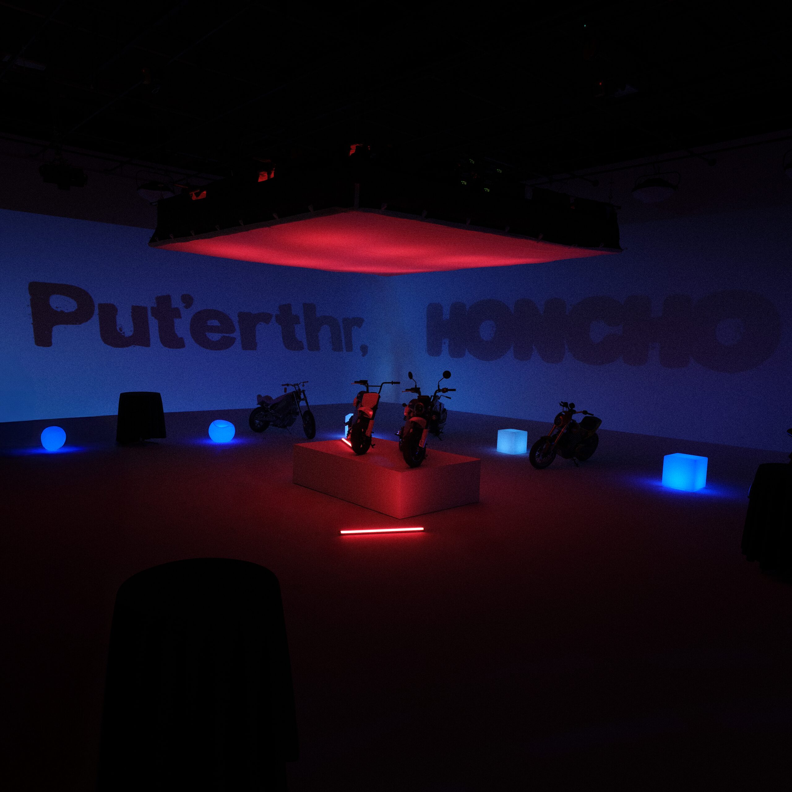 Honcho stage set with motorcycles under red and blue lighting