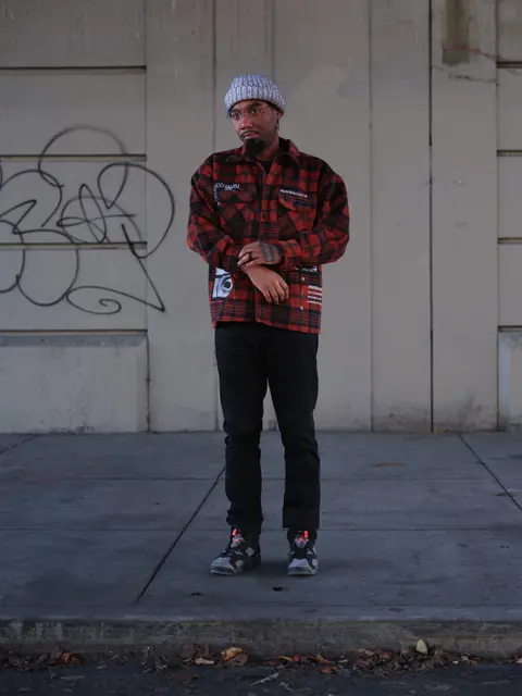 Street portrait, red flannel against graffiti wall