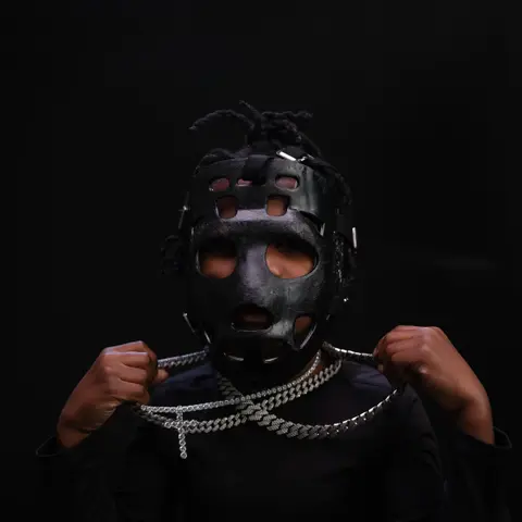 Portrait wearing goalie mask with layered chains