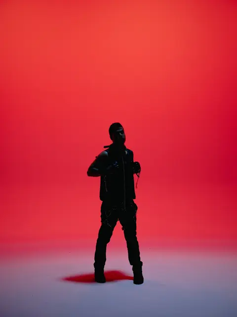 ILoveMakonnen as a black silhouette against a red studio backdrop